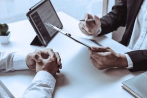 Dos personas reunidas en una mesa de trabajo revisando documentación relacionada con el Borrador de la OEP 2025 y el acceso al empleo público en la Administración General del Estado.