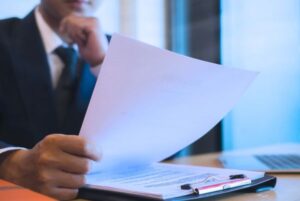 Persona revisando documentos oficiales relacionados con el listado definitivo de admitidos GSI en una oposición TIC del Estado.