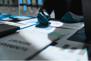 Persona revisando gráficos y documentos relacionados con el informe Panorama de las Administraciones Públicas 2025 de la OCDE sobre eficiencia gubernamental y participación ciudadana.