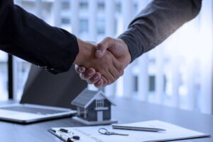Dos personas estrechándose la mano tras firmar documentos, representando el momento de toma de posesión tras aprobar una oposición.