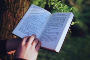 Persona leyendo un libro al aire libre como parte de la preparación de oposiciones TIC en verano.