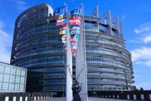 Fachada del Parlamento Europeo con banderas de los Estados miembros, símbolo de la Unión Europea.