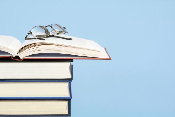 Montón de libros con gafas encima, símbolo de estudio y técnicas de memorización.