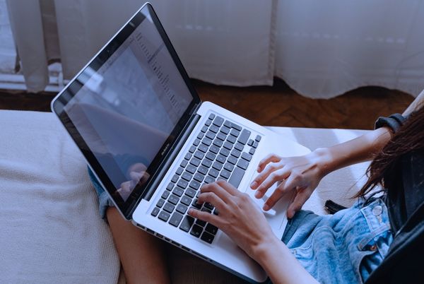 Persona utilizando un ordenador portátil en un entorno doméstico, en contexto de trabajo relacionado con el nuevo paquete de ciberseguridad de la Comisión Europea.