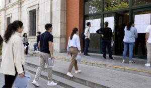 Opositores consultando la distribución por sedes y aulas antes del examen de A1.